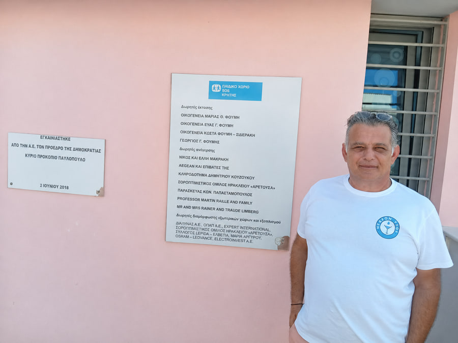 En tekniker från NearonYdor vid SOS Barnby på Kreta, bredvid byns givartavla